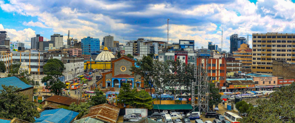 Panoramic view of Nairobi's skyline from Muthurwa, featuring a domed church, busy market streets, and the city CBD in the background.