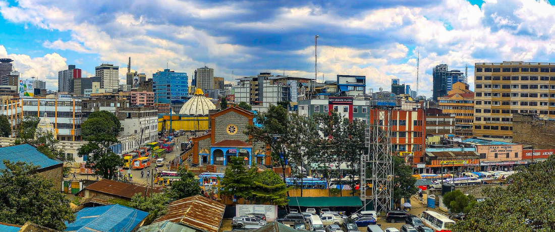Panoramic view of Nairobi's skyline from Muthurwa, featuring a domed church, busy market streets, and the city CBD in the background.